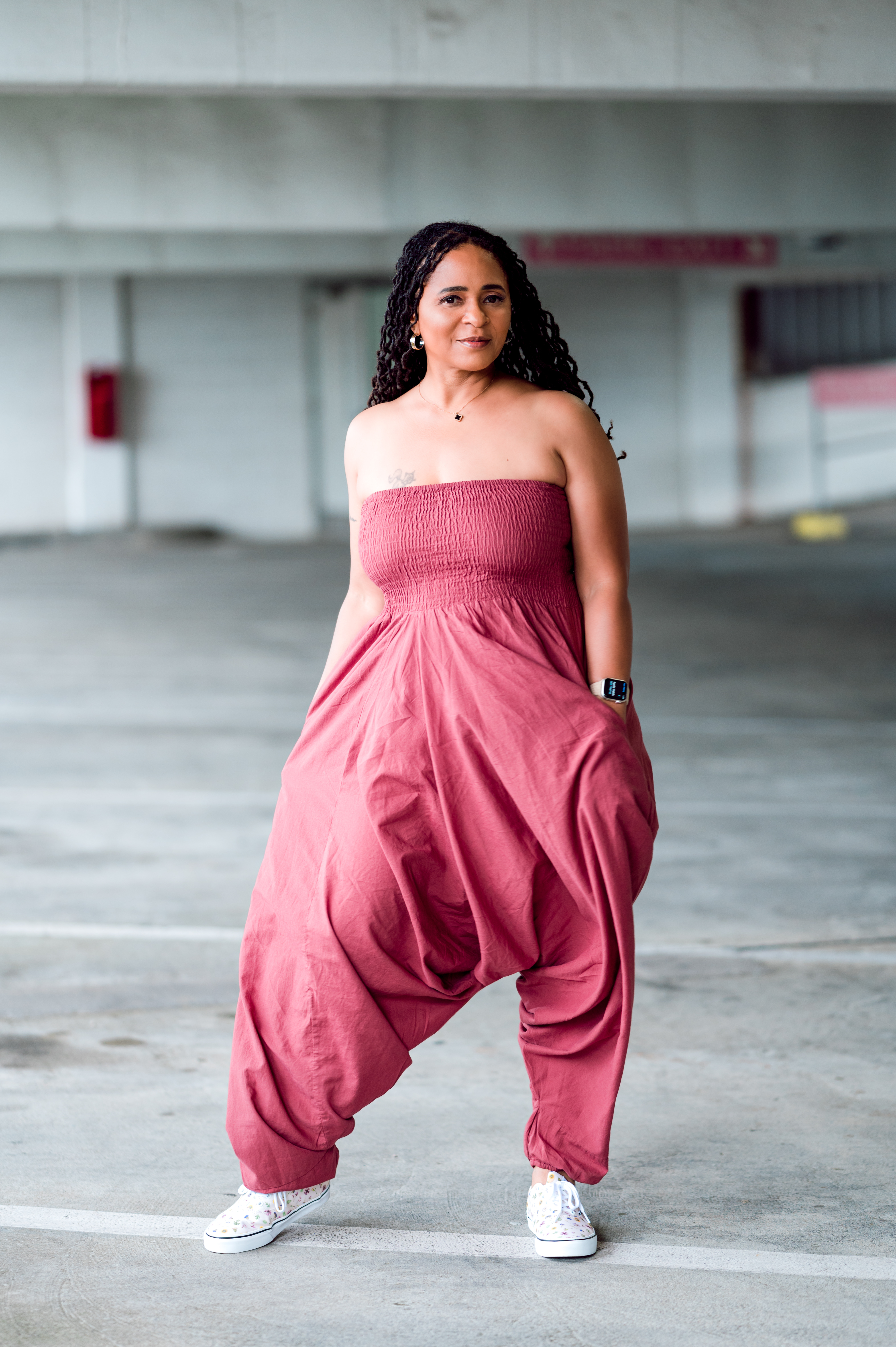 Woman standing in parking garage with hands in pockets